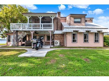Charming two-story home with a balcony, well-maintained lawn, and a concrete path leading to the entrance at 12228 Kirby Smith Rd, Orlando, FL 32832