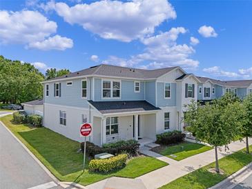 Charming two-story townhome with a light blue exterior, well-manicured lawn, and a welcoming front porch at 1324 Painted Bunting Ave, Oakland, FL 34787