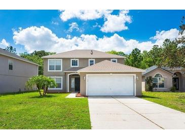 Charming two-story home with a well-manicured lawn and attached two car garage on a sunny day with blue sky at 2020 Corner Glen Dr, Orlando, FL 32820
