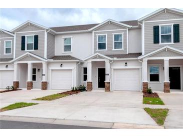 Charming townhomes featuring individual garages and lovely architectural details, offering modern comfort and curb appeal at 3239 Laurent Loop, Davenport, FL 33837