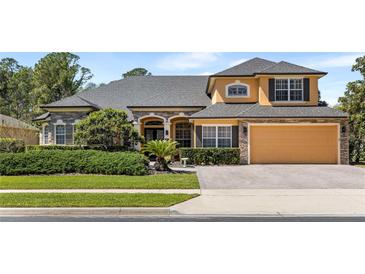 Charming home featuring stone accents, manicured landscaping, and an attached two-car garage at 3418 Turningwind Ln, Winter Garden, FL 34787