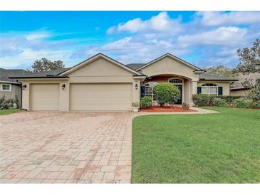 Charming single-story home featuring a brick driveway, three-car garage, and well-manicured lawn at 440 Skyview Pl, Chuluota, FL 32766