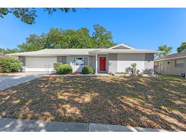 Charming single-story home with a red front door, manicured landscaping, and attached garage at 611 Green Briar Blvd, Altamonte Springs, FL 32714