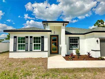 Charming single-story home featuring a modern design, decorative shutters, and a beautifully landscaped front yard at 701 Marion Oaks Trl, Ocala, FL 34473
