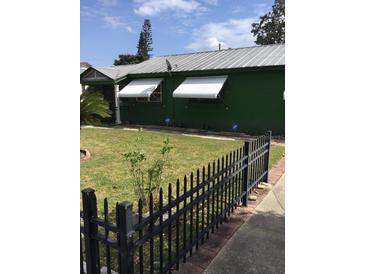 Charming home featuring a dark green exterior, metal roof, fenced yard and white window awnings at 710 W Swoope W Ave, Winter Park, FL 32789