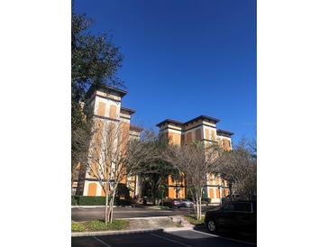 Low-angle exterior of building with parking lot in front, trees surrounding and blue sky above at 12527 Floridays Resort Dr # 603E, Orlando, FL 32821