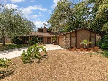 Charming single-story home featuring a combination of wood and stone facade, with a well-manicured front yard at 490 Burnt Tree Ln, Apopka, FL 32712