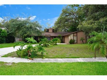 Charming single-story home with lush landscaping and a well-manicured lawn at 490 Burnt Tree Ln, Apopka, FL 32712