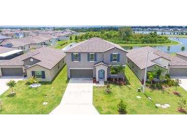 Inviting two-story home featuring a well-manicured lawn and a scenic view of the surrounding community at 5553 Turkey Creek Way, Lakeland, FL 33811