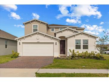Charming two-story home featuring a brick driveway, a two-car garage, and manicured landscaping at 1103 Silo Dr, St Cloud, FL 34771