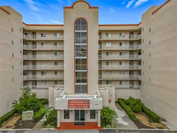 Multi-story condo building featuring balconies, red roof accents, landscaping, and street-facing entry with the address 1150 at 1150 Carmel Cir # 301, Casselberry, FL 32707