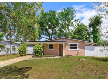 Charming single-story home with a covered parking area and well-maintained front lawn at 1219 Helen St, Apopka, FL 32703