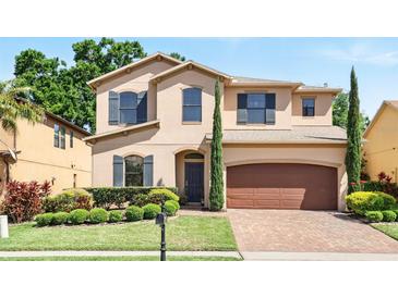 Charming two-story home featuring manicured landscaping, a brick driveway, and a two-car garage at 1558 Terra Verde Way, Ocoee, FL 34761