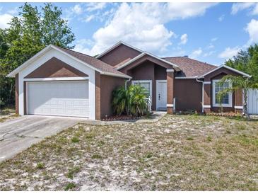Charming single-Gathering home with a two-car garage and landscaping, ready for new owners at 1606 Bismarck Dr, Deltona, FL 32725