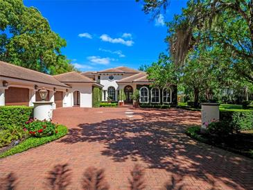 Stunning home with a meticulously landscaped front yard and a brick driveway leading to a multi-car garage at 2001 Bett Mar Ln, Winter Park, FL 32789