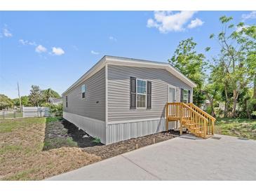 Charming grey home with a well-maintained lawn and new front steps at 4425 Mobilaire Dr, Orlando, FL 32822