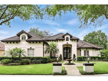 Stunning single-story home with a tile roof, manicured lawn, beautiful landscaping, and a front fountain at 4517 Old Carriage Trail, Oviedo, FL 32765