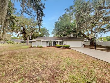Charming single-story home featuring mature trees, a well-maintained lawn, and an attached two-car garage at 5212 Waterwood Run, Bartow, FL 33830