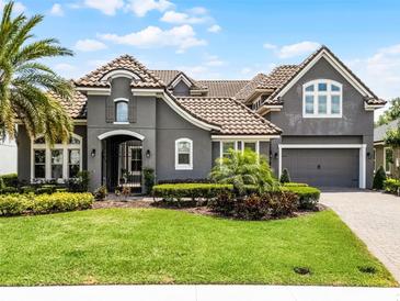 Beautiful two-story home with a well-manicured lawn, lush landscaping, and a gray exterior at 3863 Grassland Loop, Lake Mary, FL 32746