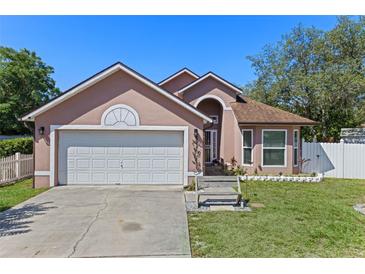 Charming single-Gathering home featuring a two-car garage and beautifully landscaped front yard, complemented by a sunny blue sky at 9301 Echo Run, Orlando, FL 32817