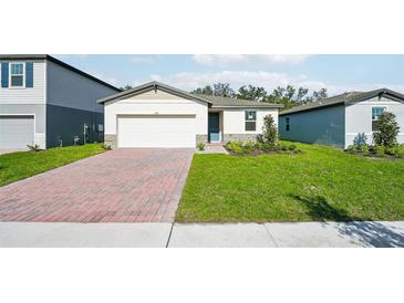 Charming single-story home featuring a brick driveway, well-maintained lawn, and neutral-colored exterior at 4709 Jasmine Cir, Leesburg, FL 34748