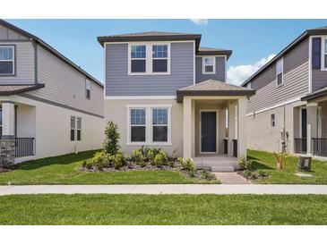 Charming two-story home featuring a beautifully landscaped yard and inviting front porch at 5139 Passion Flower Way, Winter Garden, FL 34787