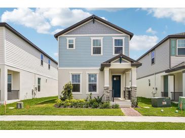 Charming two-story home with blue siding, stone accents, and a well-maintained front yard at 5235 Passion Flower Way, Winter Garden, FL 34787