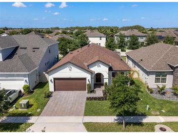 Beautiful single-story home with well-manicured lawn, brick driveway, and attached garage at 12188 Ryegrass Trl, Orlando, FL 32824