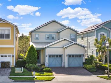 Charming two-story home with a manicured lawn and two-car garage with blue doors at 1449 Fairview Cir, Reunion, FL 34747
