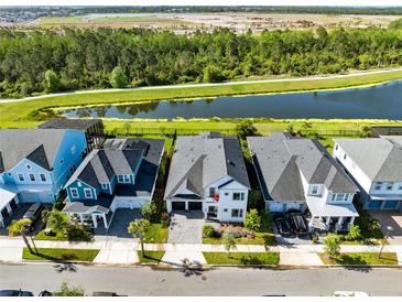 Gorgeous aerial view of the homes and community featuring a large pond and green space at 14749 Walcott Ave, Orlando, FL 32827