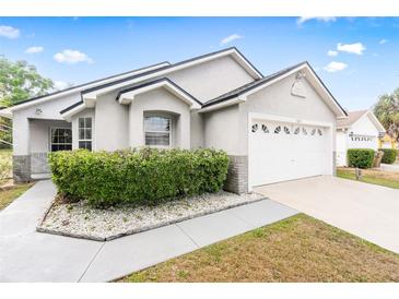 Charming single-story home featuring a well-maintained front yard, attached garage, and neutral exterior paint at 1631 Oak Hill Trl, Kissimmee, FL 34747
