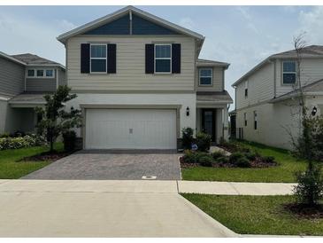 Two-story home with a two-car garage and a well-maintained front yard, highlighting curb appeal at 2620 Blowing Breeze Ave, Kissimmee, FL 34744