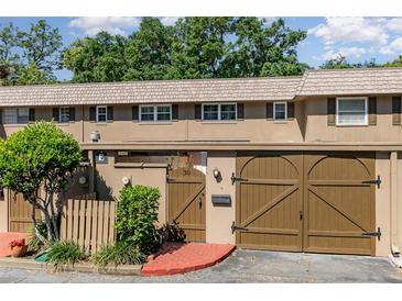 Charming townhouse featuring a well-maintained exterior with a private entrance, brick accents, and attached garage at 3104 Harrison Ave # E-30, Orlando, FL 32804