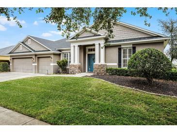 Charming single-Gathering home with well-manicured lawn and stone accents on the front columns at 413 Macchi Ave, Oakland, FL 34787