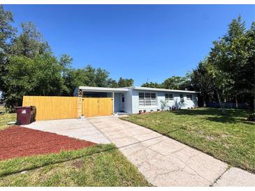 Charming single-story home with a well-maintained lawn, fenced yard, and a long driveway leading to the entrance at 511 S Alder Ave, Orlando, FL 32807