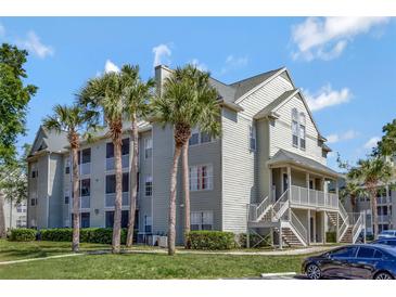 Inviting condo complex with tropical palm trees, lush green lawn, and ample parking at 6142 Westgate Dr # 204, Orlando, FL 32835
