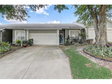 Charming single-story home with a two-car garage, featuring mature landscaping and a well-maintained lawn at 682 Lexington Dr, Clermont, FL 34711