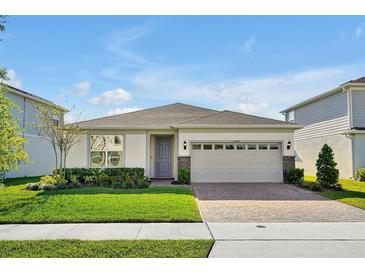 Beautiful single-story home featuring a well-maintained lawn, stone accents, and a two-car garage at 10002 Brown Burrow St, Orlando, FL 32829