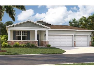 Beautiful single-Gathering home with a three-car garage, landscaped yard and classic architectural details at 12989 Trovita Dr, Grand Island, FL 32735