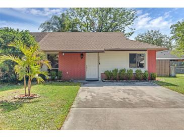 Charming single-story home with a well-manicured lawn and brick accents on the facade at 1397 Candlewyck Dr, Orlando, FL 32807