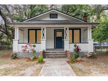 Charming single-story home with a welcoming front porch, garden beds, and a well-manicured yard at 2504 Yale Ave, Sanford, FL 32773