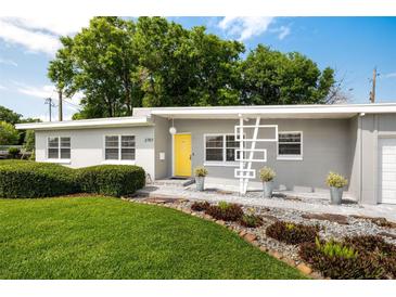 Charming one-story home with a well-manicured lawn, minimalist yard art, and a bright yellow front door at 2707 Chelsea St, Orlando, FL 32803