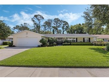 Charming single-story home featuring a lush front lawn, manicured landscaping, and a two-car garage at 3015 Dawley Ave, Orlando, FL 32806