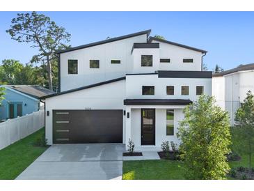 Stunning modern home with a two-car garage, black trim, and a well-manicured lawn at 3608 Dubsdread Cir, Orlando, FL 32804