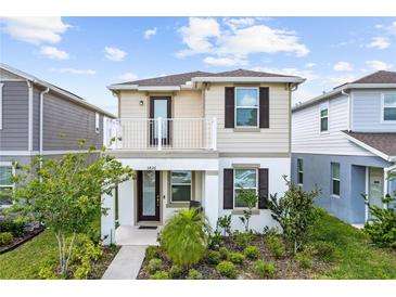 Two-story home featuring a charming balcony and well-maintained front yard at 5826 Wooden Pine Dr, Orlando, FL 32829