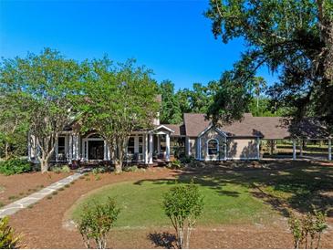 Charming home with a well-manicured lawn and a covered carport, surrounded by mature trees at 6037 Lake Erie Rd, Groveland, FL 34736