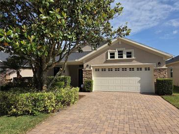 Charming home features a brick-paved driveway and well-manicured landscaping at 110 Sophia Marie Cv, Sanford, FL 32771