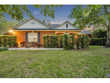 Charming single-story brick home with a well-manicured lawn and mature landscaping at 1130 Roxboro Rd, Longwood, FL 32750