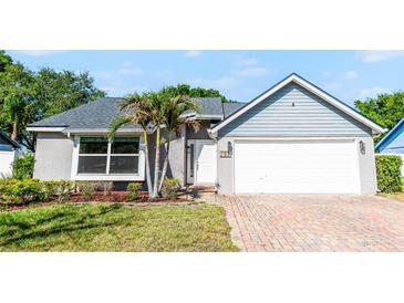 Charming single-story home featuring a gray exterior, well-maintained landscaping, and a brick-paved driveway leading to a two-car garage at 150 Dempsey Way, Orlando, FL 32835