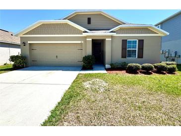 Charming single-story home with a well-manicured lawn and a neutral-colored exterior at 216 Grove Branch Rd, Winter Haven, FL 33880